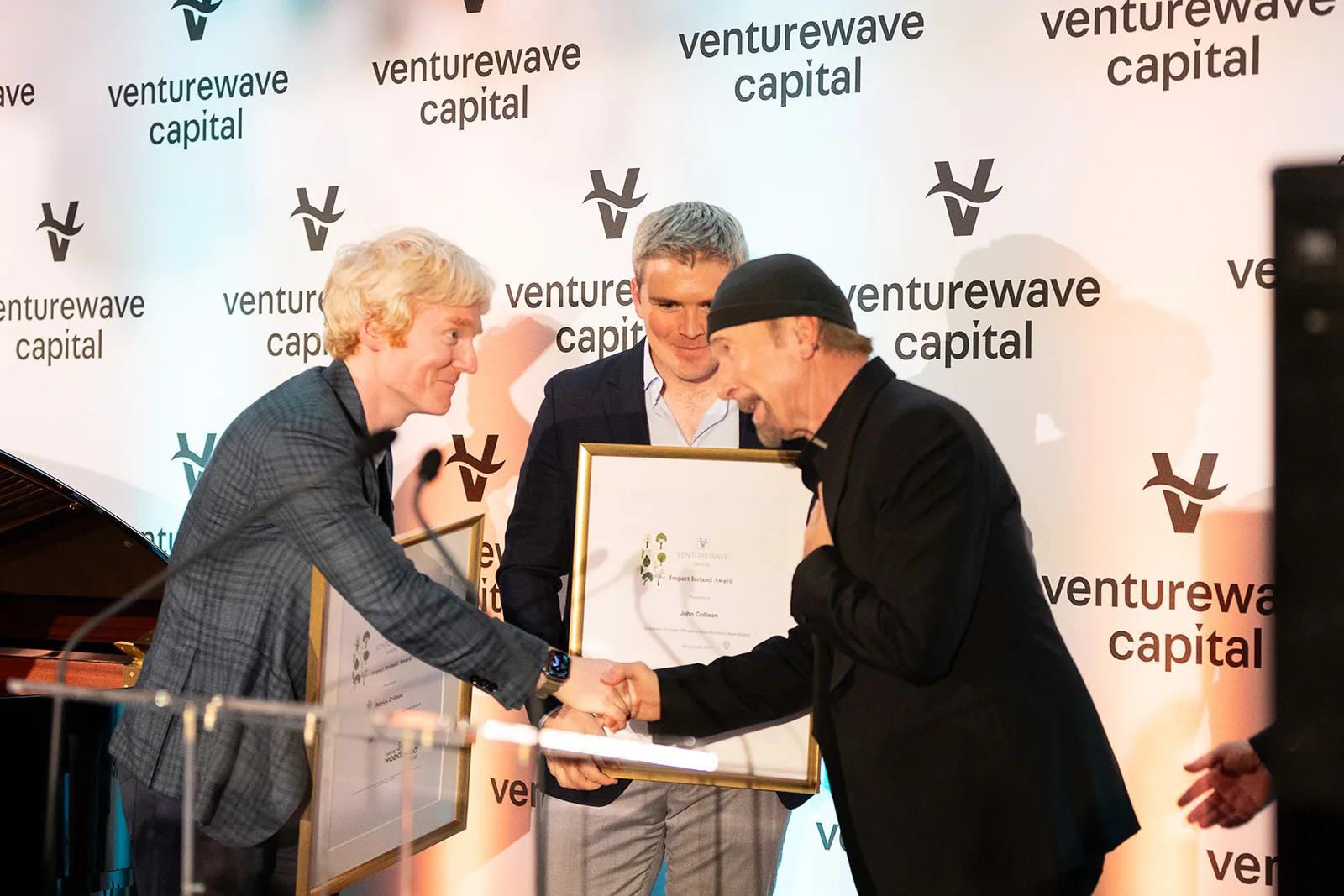 Patrick and John Collison with The Edge at the 2025 Impact Ireland Award presentation