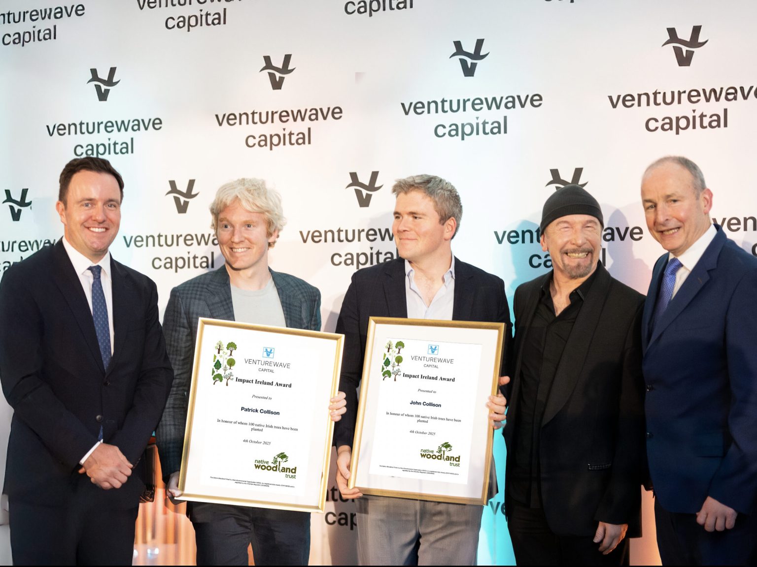 Patrick and John Collison receiving the Impact Ireland Award 2025 with Alan Foy, The Edge and Micheál Martin